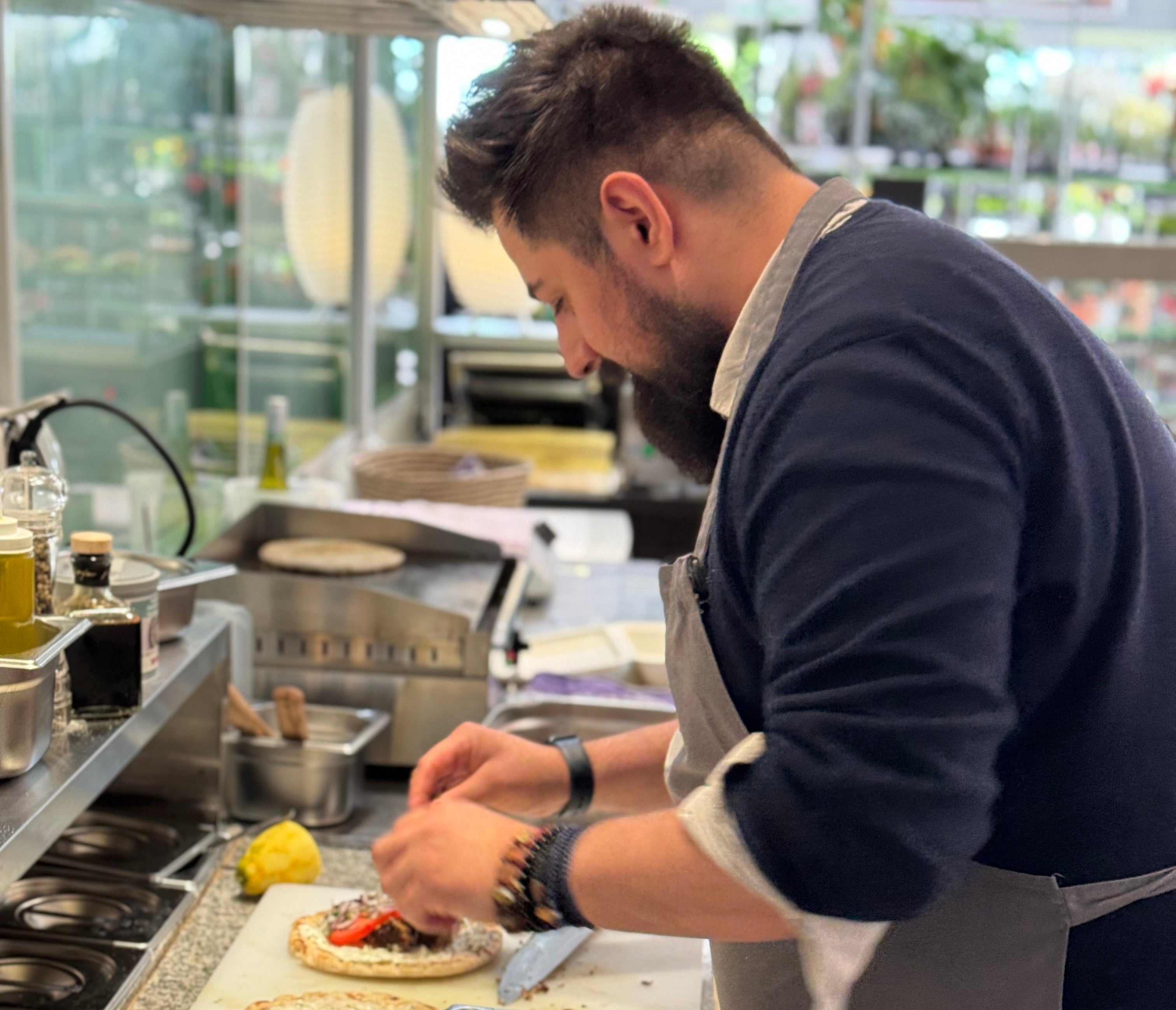 Zubereitung mediterraner Spezialitäten im Christos Bistro – Handwerk, Frische & Feinkost