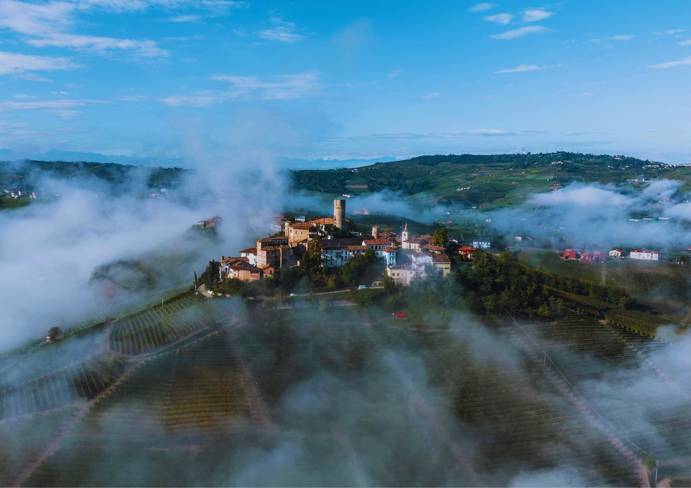 Morgennebel über einem historischen Dorf in den Hügeln.