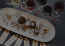„Auswahl feiner Desserts zu mehreren Gläsern Rot- und Weißwein“