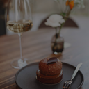 „Feines Schokoladendessert zu einem Glas goldfarbenem Dessertwein“