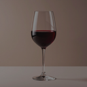 „Glas Rotwein vor einem dezenten, warmen Hintergrund“