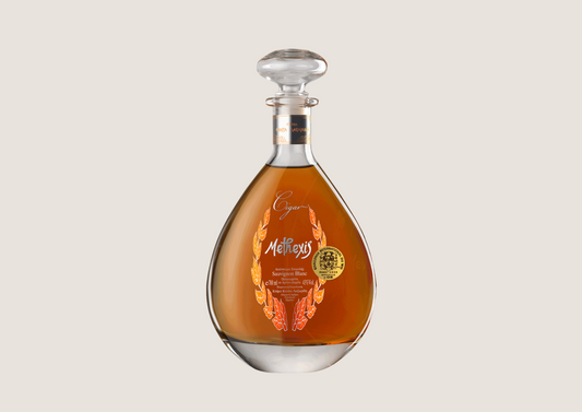 Elegante Glasflasche mit bernsteinfarbener Spirituose und edlem Etikett in Tropfenform.