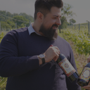 „Mann mit griechischer Weinflasche in einem Weinberg“