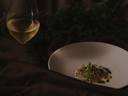„Glas Weißwein zu einem fein angerichteten Gericht beim Food Pairing“